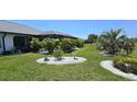Lush backyard featuring manicured landscaping, a screened-in lanai, and well-maintained lawn at 7148 N Blue Sage, Punta Gorda, FL 33955