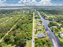 Aerial view of a waterfront property, showcasing the home, expansive yard, and canal access at 1025 Cheshire St, Port Charlotte, FL 33953