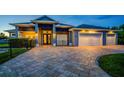 Exterior view of a modern home with a well-manicured lawn and a paver driveway at 1025 Cheshire St, Port Charlotte, FL 33953