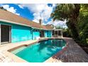 Private backyard featuring a sparkling pool, brick patio, screened lanai and lush landscaping at 10289 60Th N Cir, Pinellas Park, FL 33782