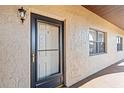 Exterior view of the building's front door with the unit number and textured walls at 1217 Aqui Esta Dr # 5, Punta Gorda, FL 33950