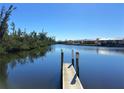 Scenic view of the serene waterfront area with a private dock and lush greenery at 1217 Aqui Esta Dr # 5, Punta Gorda, FL 33950