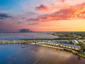 Sunset view of the waterfront condos with pier, beach, and pool, creating the perfect coastal retreat at 14459 River Beach Dr # 112, Port Charlotte, FL 33953