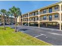 View of the condos on stilts with ground level parking and palm trees in the landscaping at 14459 River Beach Dr # 112, Port Charlotte, FL 33953