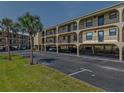 View of the condos on stilts with ground level parking and palm trees in the landscaping at 14459 River Beach Dr # 112, Port Charlotte, FL 33953
