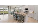 Bright, open kitchen with white cabinets, marble countertops, and stainless steel appliances, overlooking dining area at 15968 Crofton Springs Way, Port Charlotte, FL 33953
