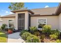 Inviting entrance with screen, well-lit walkway, and beautifully maintained garden at 16094 Ortega Dr, Punta Gorda, FL 33955