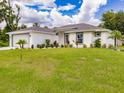 An attractive single-Gathering home featuring a spacious lawn and nicely landscaped front yard at 17130 Elder St, Port Charlotte, FL 33954