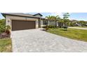 Long driveway leads to a well-manicured home and garage with lush landscaping at 1734 Saddlewood Cir, Port Charlotte, FL 33953