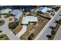 An aerial view of the house shows its waterfront location with a canal behind and a clean, well-maintained yard at 190 Casa Ln, Punta Gorda, FL 33950