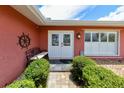 Inviting front entrance with a cozy bench, well-maintained landscaping and decorative ships wheel accent at 190 Casa Ln, Punta Gorda, FL 33950