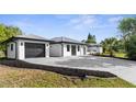 Exterior shot of property shows the home's driveway, metal roof and freshly painted exterior at 19723 Midway Blvd, Port Charlotte, FL 33948