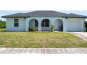 Lovely single-story home showcasing a manicured lawn and a convenient one-car attached garage at 2271 Alton Rd, Port Charlotte, FL 33952