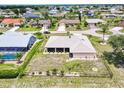 Aerial view of a fenced-in backyard with landscaping, showcasing the home's setting in a residential neighborhood at 25379 Paladin Ln, Punta Gorda, FL 33983