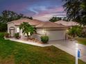 Charming single-story home featuring a tile roof, two-car garage, and well-maintained landscaping at 26111 Feathersound Dr, Punta Gorda, FL 33955