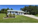 Charming single-story home with a manicured lawn, quaint carport, and inviting front porch at 2805 Gussie St, Punta Gorda, FL 33950