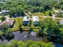 Aerial shot of home with two-car garage on a canal, lush foliage, and a sunny sky at 3616 Allapatchee Dr, Punta Gorda, FL 33950