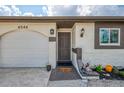 Close-up of the home's entrance featuring a neutral-colored front door, garage, and decorative accents at 4044 S Salford Blvd, North Port, FL 34287