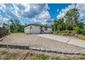 Single-story home featuring a neatly graveled front yard, a driveway, and an attached garage, complemented by decorative stone edging at 4044 S Salford Blvd, North Port, FL 34287