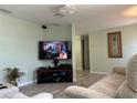 Comfortable living room with wood flooring, light green walls, and a modern TV set for relaxing entertainment at 4089 Yucatan Cir, Port Charlotte, FL 33948
