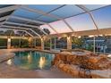 Relaxing screened pool and spa area with beautiful rock features and lush tropical landscaping at 4317 Mccullough St, Port Charlotte, FL 33948