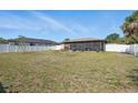 Large backyard featuring a screened-in lanai and a white vinyl fence at 4358 Pates St, Port Charlotte, FL 33948
