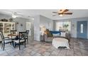 Cozy living room with neutral tile flooring, ceiling fans, and a decorative front door at 4358 Pates St, Port Charlotte, FL 33948