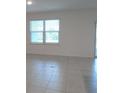 Bright living room with tile flooring, a large window, and sliding glass doors at 4830 Cazes Ave, North Port, FL 34287