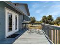 View of outdoor deck with metal table and chairs and backyard views at 6421 Grove Blvd, Punta Gorda, FL 33982