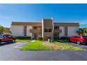 A well-maintained exterior elevation of a two-story condo building with parking and manicured lawn at 1080 Bal Harbor Blvd # 12C, Punta Gorda, FL 33950