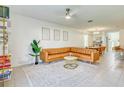 Bright living room with a leather sectional sofa, ceiling fan, and modern décor at 111 Rain Lily Ave, Spring Hill, FL 34609