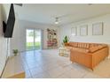 Comfortable living room featuring a sliding glass door to the backyard and a cozy seating arrangement at 111 Rain Lily Ave, Spring Hill, FL 34609