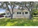 Quaint single-story house with a large porch, nestled amidst mature trees and lush greenery at 1250 Lemon St, Punta Gorda, FL 33950