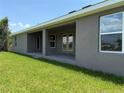 View of the home's covered back patio, accessible through glass doors and windows at 13346 High Springs Ave, Port Charlotte, FL 33981