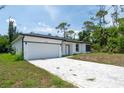 Exterior view of a single-story home showcasing a well-maintained front yard and a paved driveway at 16218 Chamberlain Blvd, Port Charlotte, FL 33954