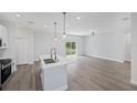 Bright, open-concept kitchen with island, stainless appliances, and modern pendant lighting at 16218 Chamberlain Blvd, Port Charlotte, FL 33954