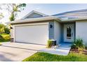 Contemporary home showcases a two-car garage and decorative rock landscaping leading to the front door at 16280 Minorca Dr, Punta Gorda, FL 33955