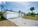 A modern single-story house shows off a paved driveway leading to an attached two car garage at 17197 Russell Ave, Port Charlotte, FL 33954