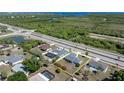 Aerial view of property showing its location near a highway, with lush greenery, pond, and a partial water view at 19468 Edgewater Dr, Port Charlotte, FL 33948