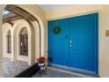 Inviting entrance with a bright blue double door, decorative wreath, and arched windows at 2152 Taiwan Ct, Punta Gorda, FL 33983