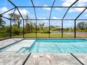 Sparkling pool and enclosure with clear blue skies in the backyard at 223 Australian Dr, Rotonda West, FL 33947