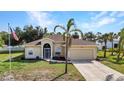 Inviting single Gathering home featuring a two-car garage, mature palm trees, and a well-manicured lawn at 2300 Carpenter Ln, North Port, FL 34286