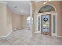 Open-concept living room with tile flooring, arched doorways, and neutral paint tones at 2300 Carpenter Ln, North Port, FL 34286