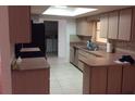 Functional kitchen with ample counter space, wood cabinets, and view to laundry area at 23220 Rountree Ave, Port Charlotte, FL 33980