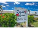 The Lakeside Gardens community sign with tropical landscaping, flowering bushes and beautiful blue sky at 26333 Nadir Rd # 111, Punta Gorda, FL 33983