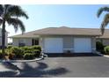 Charming home exterior with a paved driveway, two-car garage, complemented by neat landscaping at 26333 Nadir Rd # 111, Punta Gorda, FL 33983