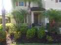 Lush landscaping surrounds the front porch of this inviting home, complete with seating at 2739 Sherman Oak Dr, North Port, FL 34289