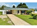 Inviting single-story home featuring a covered carport, well-maintained lawn, and mature landscaping at 3122 Scranton St, Port Charlotte, FL 33952