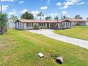 Landscaped single-story home with a long driveway and well-manicured lawn at 315 Holly Rd, Venice, FL 34293