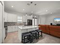 Modern kitchen with white cabinets, granite countertops, and island seating, open to living room at 3302 Palm Dr, Punta Gorda, FL 33950